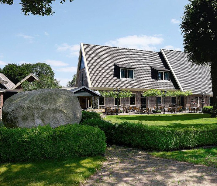 De Zwerfkei met tuin, terras en grote zwerfkei voor het gebouw